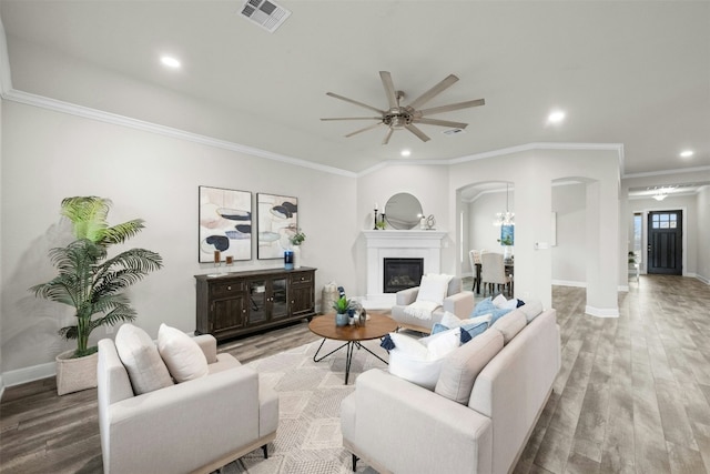 259 N Sage Holw, Dripping Springs, TX 78620 - living room with arched walkways, wood finished floors, ornamental molding, recessed lighting, and a ceiling fan