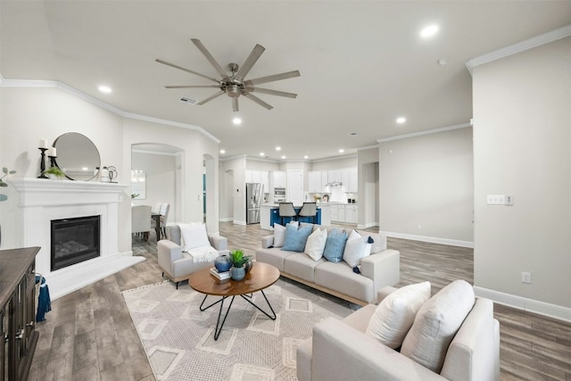 living room with ceiling fan, crown molding, and light hardwood / wood-style floors