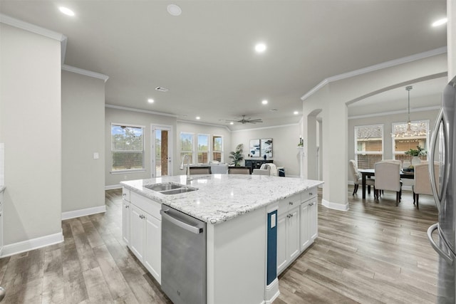 kitchen featuring sink, white cabinets, stainless steel appliances, a center island with sink, and light wood-type flooring