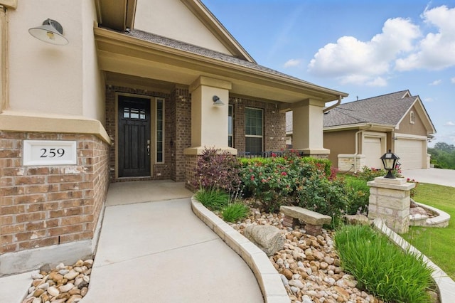 259 N Sage Holw, Dripping Springs, TX 78620 - entrance to property with a porch, brick siding, stucco siding, driveway, and a garage