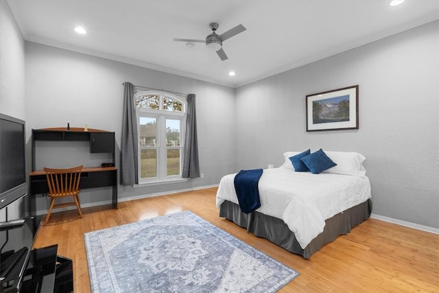 bedroom featuring hardwood / wood-style flooring, crown molding, and ceiling fan