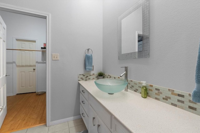 bathroom featuring tile patterned floors, vanity, and backsplash