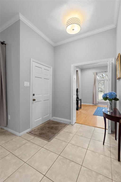 entryway featuring crown molding and light tile patterned floors