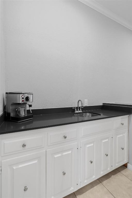 bathroom with tile patterned flooring, sink, and ornamental molding