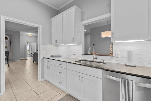 kitchen with sink, light tile patterned floors, dishwasher, white cabinets, and decorative light fixtures