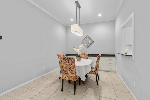 dining space with crown molding and light tile patterned floors