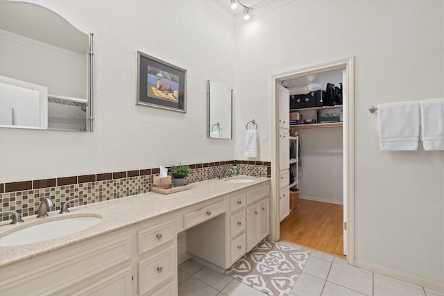 bathroom with tile patterned flooring, backsplash, vanity, and crown molding