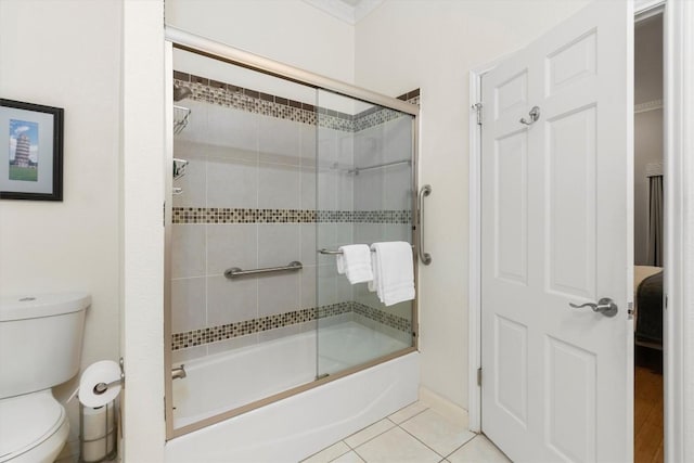 bathroom featuring tile patterned floors, enclosed tub / shower combo, and toilet