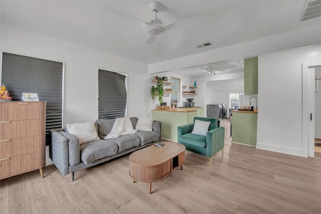 living room with ceiling fan and light wood-type flooring