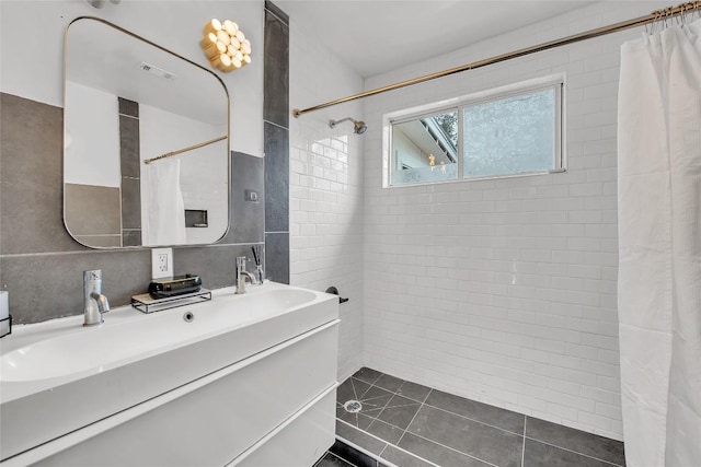 bathroom with curtained shower, tile walls, decorative backsplash, vanity, and tile patterned floors