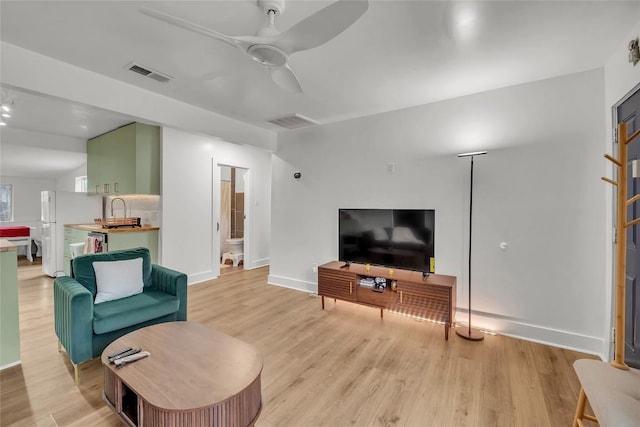 living room featuring ceiling fan and light hardwood / wood-style floors