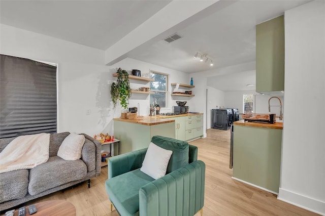 living room featuring beam ceiling and light hardwood / wood-style floors