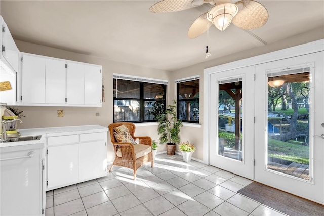 interior space with white cabinetry, ceiling fan, light tile patterned flooring, and sink