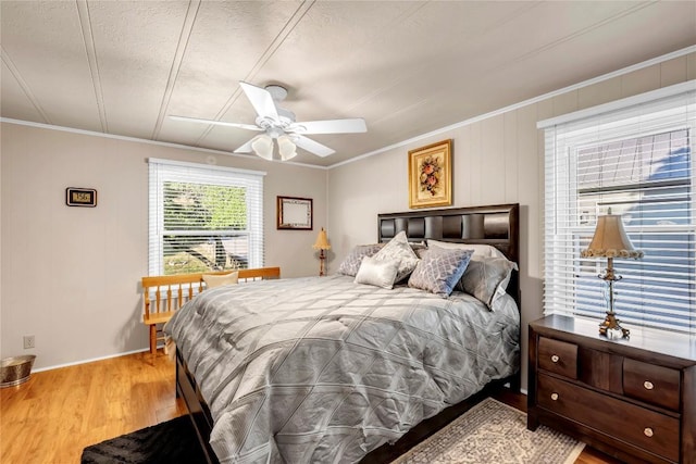 bedroom featuring crown molding, ceiling fan, a textured ceiling, and light wood-type flooring