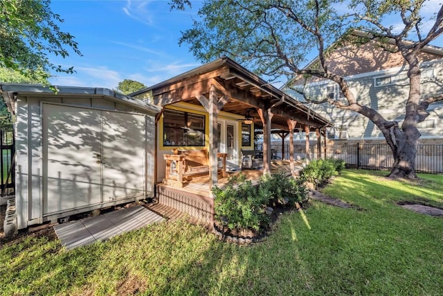 rear view of property featuring a yard, a patio area, and a shed