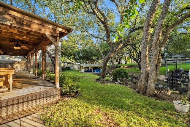 view of yard featuring a deck and ceiling fan