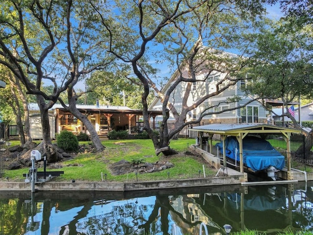 view of dock with a water view and a yard