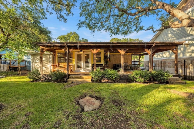 back of property featuring ceiling fan and a yard