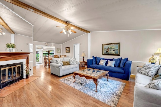 living room featuring lofted ceiling with beams, ceiling fan, and light wood-type flooring