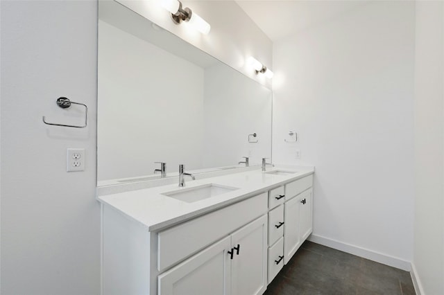 bathroom with a sink, baseboards, and double vanity