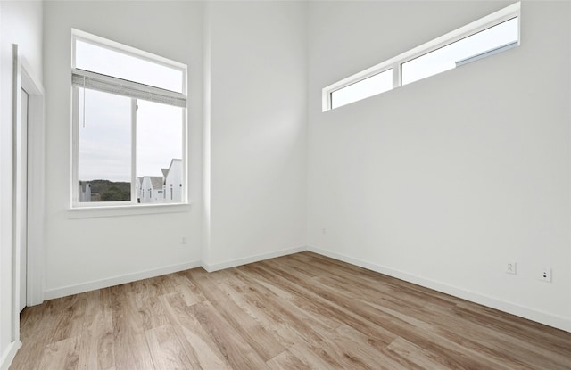 spare room featuring light wood-style flooring and baseboards