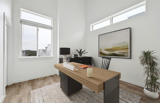 office with light wood-style flooring, baseboards, and a wealth of natural light