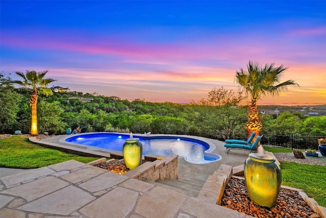 pool at dusk with a patio area, fence, and a fenced in pool