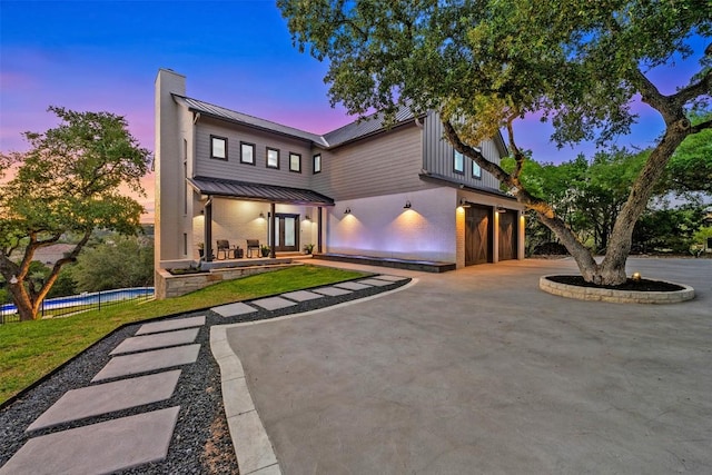 19407 White Horse Cv, Spicewood, TX 78669 - view of front of home with a standing seam roof, an attached garage, a pool, metal roof, and a chimney