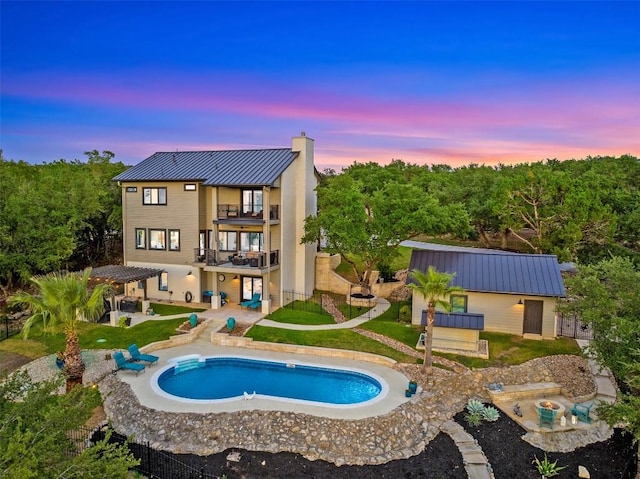 pool at dusk featuring a yard and a patio area