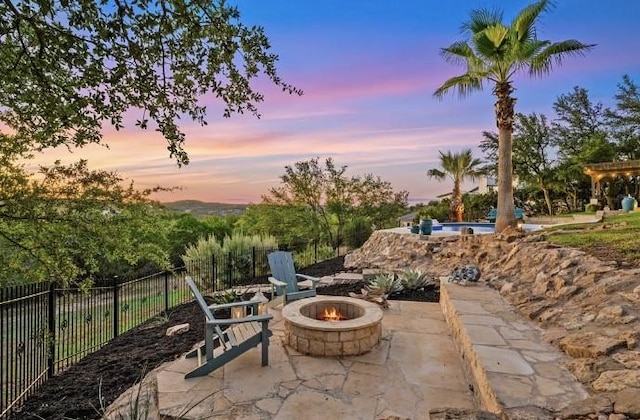 patio terrace at dusk featuring an outdoor fire pit