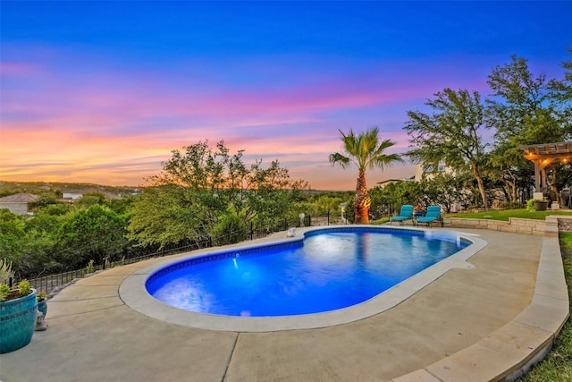 pool at dusk featuring a patio area, fence, and an outdoor pool