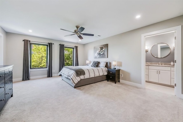 carpeted bedroom with sink, connected bathroom, and ceiling fan