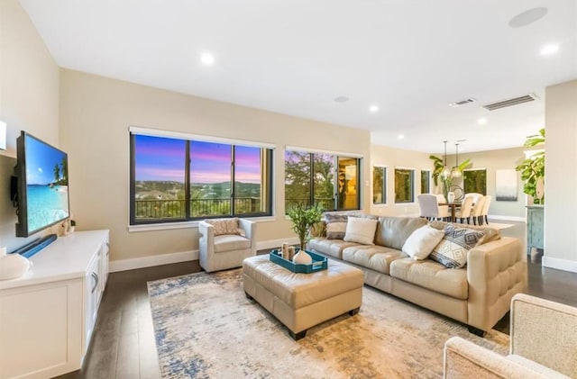 living area with recessed lighting, visible vents, baseboards, and wood finished floors