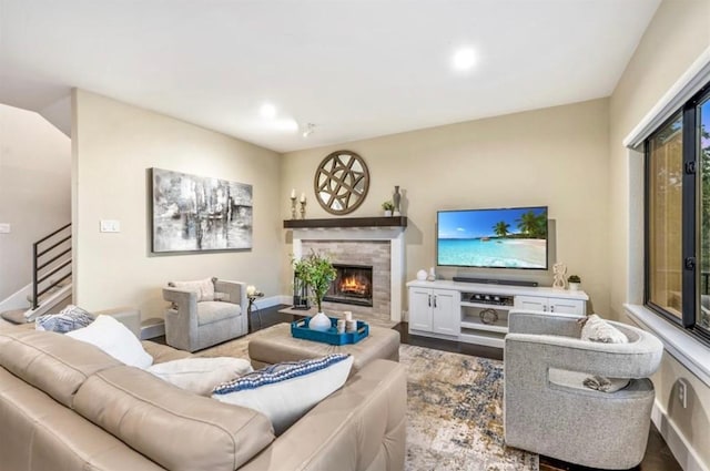 living room featuring recessed lighting, wood finished floors, baseboards, stairway, and a glass covered fireplace