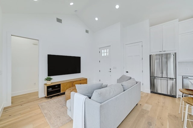 living room with lofted ceiling and light hardwood / wood-style flooring