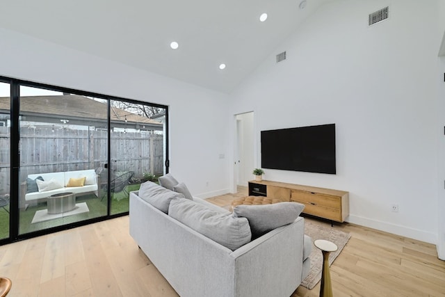 living room featuring high vaulted ceiling and hardwood / wood-style floors