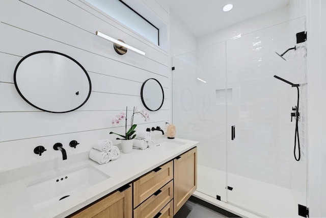 bathroom with a shower with door, vanity, and wood walls