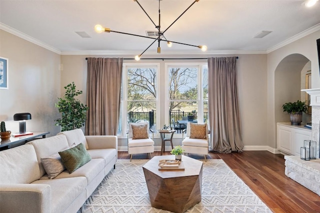 living room featuring baseboards, ornamental molding, a chandelier, and wood finished floors