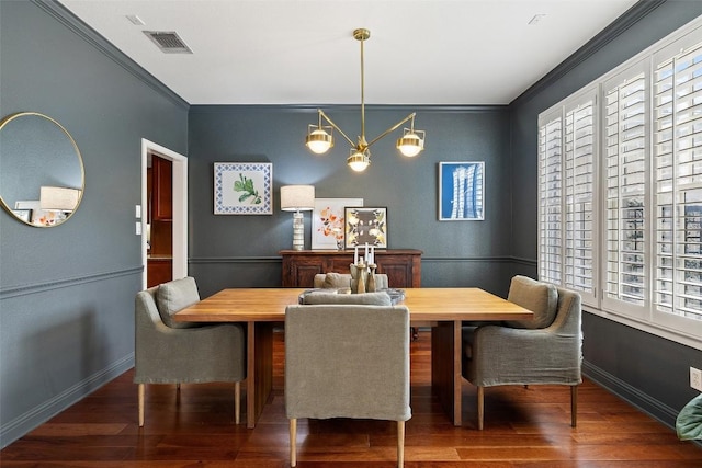 dining area featuring ornamental molding, dark wood-type flooring, visible vents, and baseboards