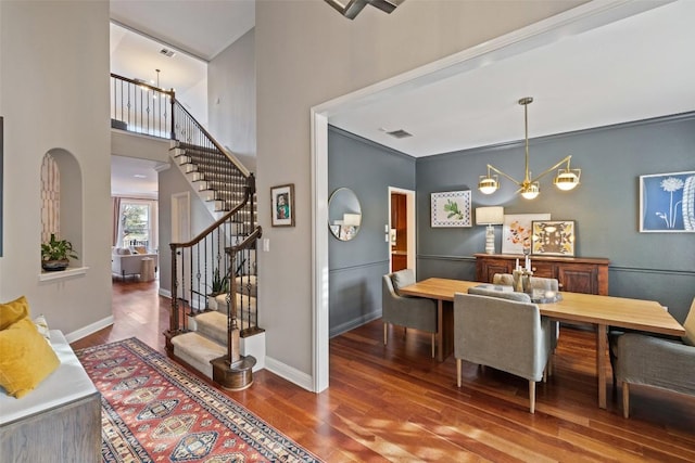 dining area featuring stairway, wood finished floors, visible vents, and baseboards