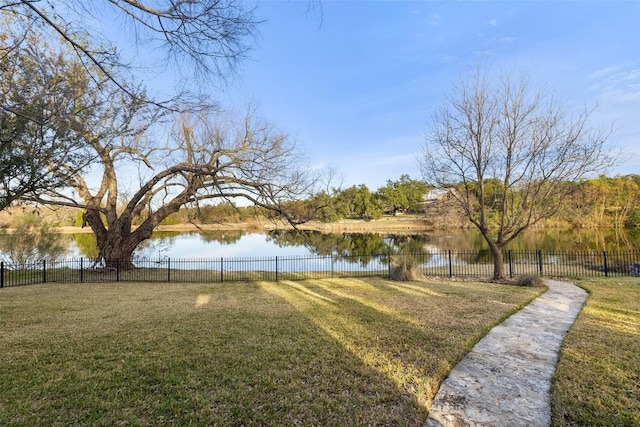 view of yard with a water view and fence