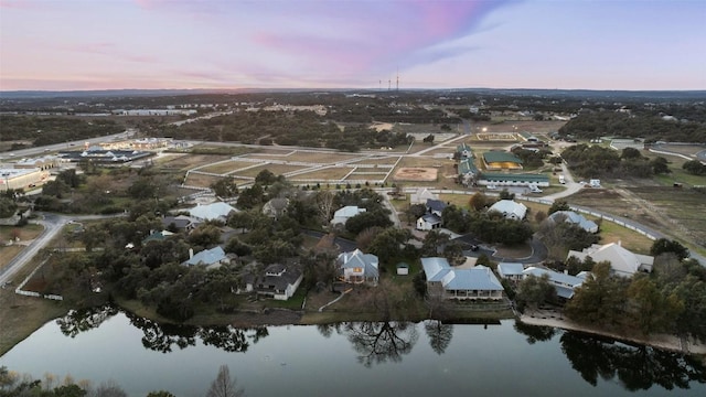 aerial view at dusk with a residential view and a water view