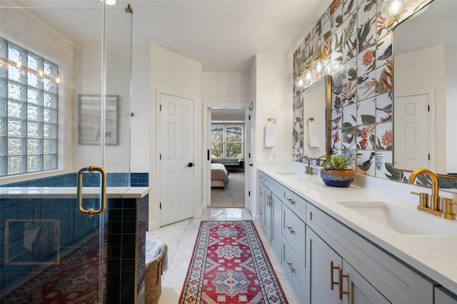 ensuite bathroom featuring double vanity, a sink, ensuite bath, and tile patterned floors