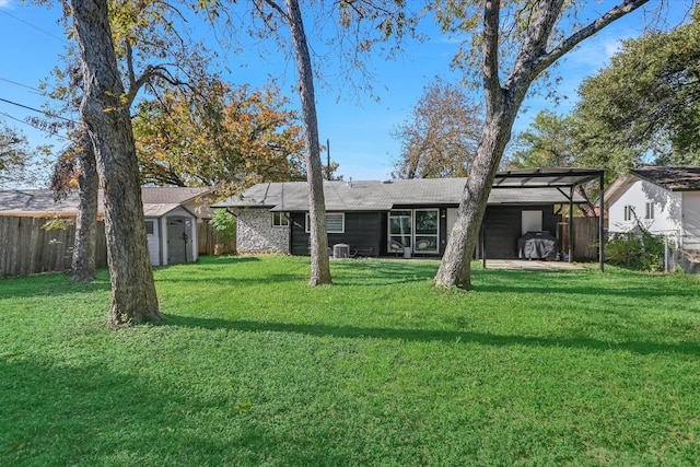 back of house featuring a yard and a storage unit