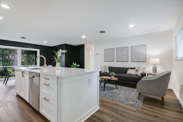 kitchen with dishwasher, white cabinetry, sink, dark wood-type flooring, and a center island with sink