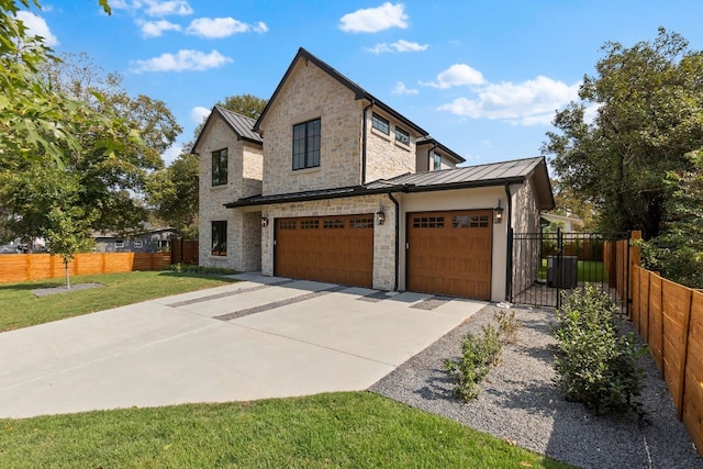 view of front of house with a garage, central AC unit, and a front yard