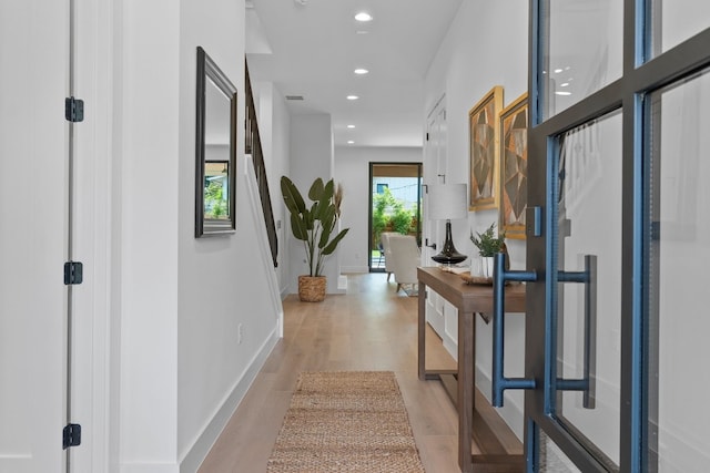 hallway with light hardwood / wood-style floors