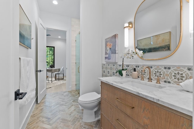 bathroom with vanity, tasteful backsplash, toilet, and walk in shower