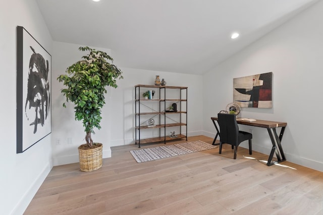 home office featuring vaulted ceiling and light hardwood / wood-style floors