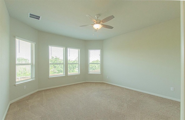 carpeted empty room with plenty of natural light and ceiling fan